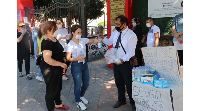 Sınava giren öğrencilere maske, su ve sakız dağıttı