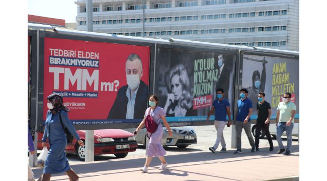 Yeşilçam'ın unutulmaz isimlerinin yer aldığı afişleri gören maskesini takıyor