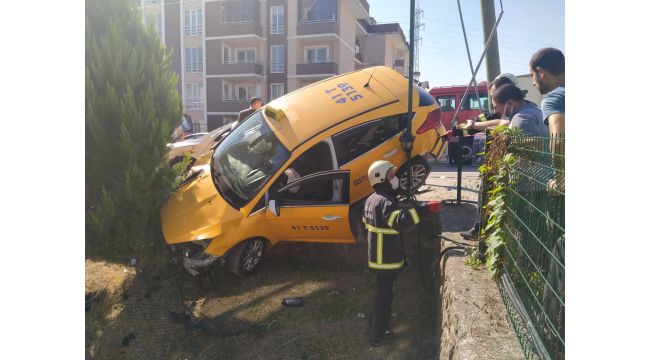 Ticari taksi bahçe duvarında asılı kaldı