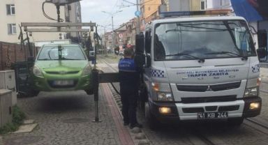Tramvay yoluna park edilen araçlar çekiliyor