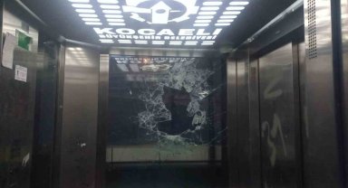 Asansörün camını kaldırım taşlarıyla parçaladı
