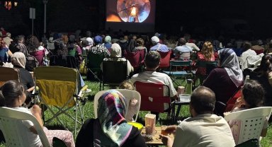 Sandalyeyi kapan açık hava sinemasına koştu